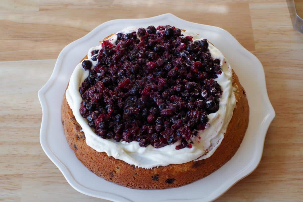 saskatoon berry filling added to whipped cream on cake