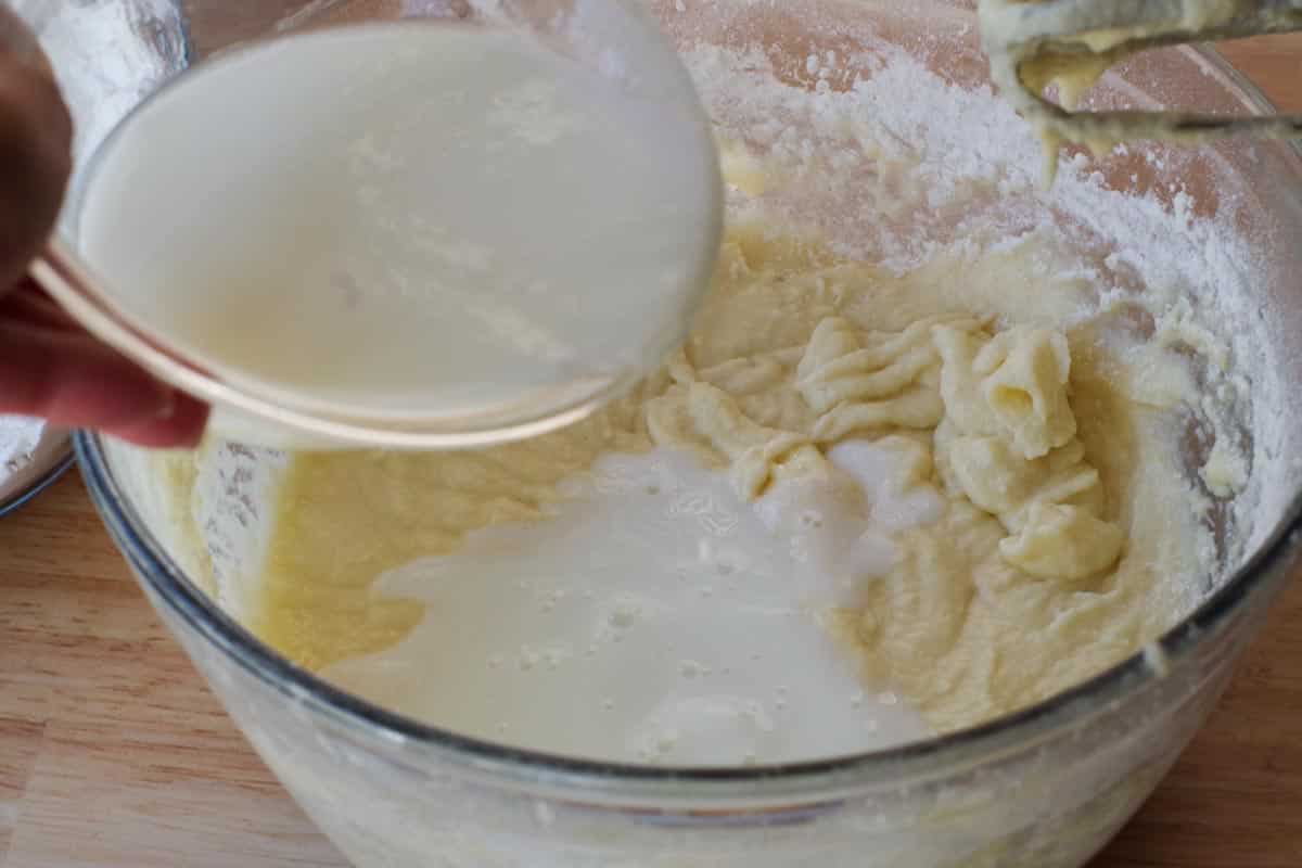 milk being poured into bowl, alternating with dry ingredients