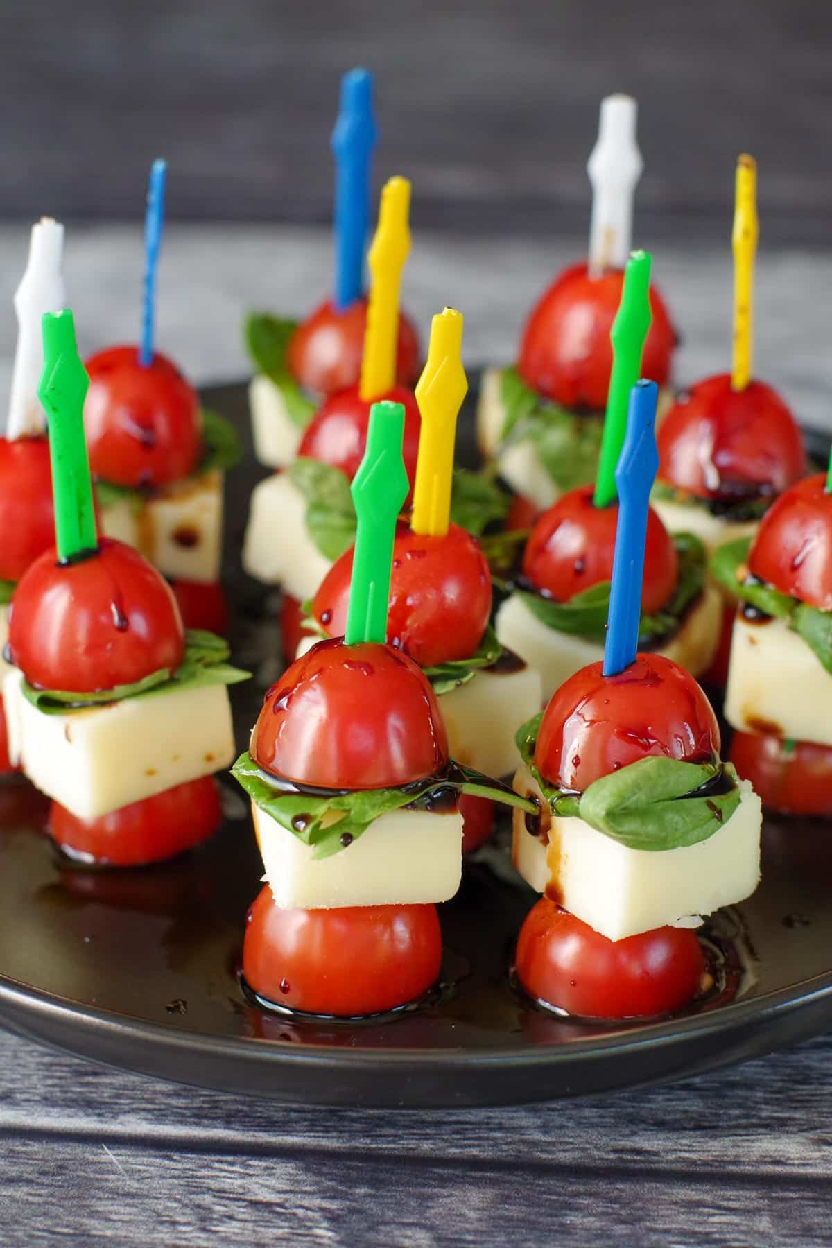 caprese bites on a black platter