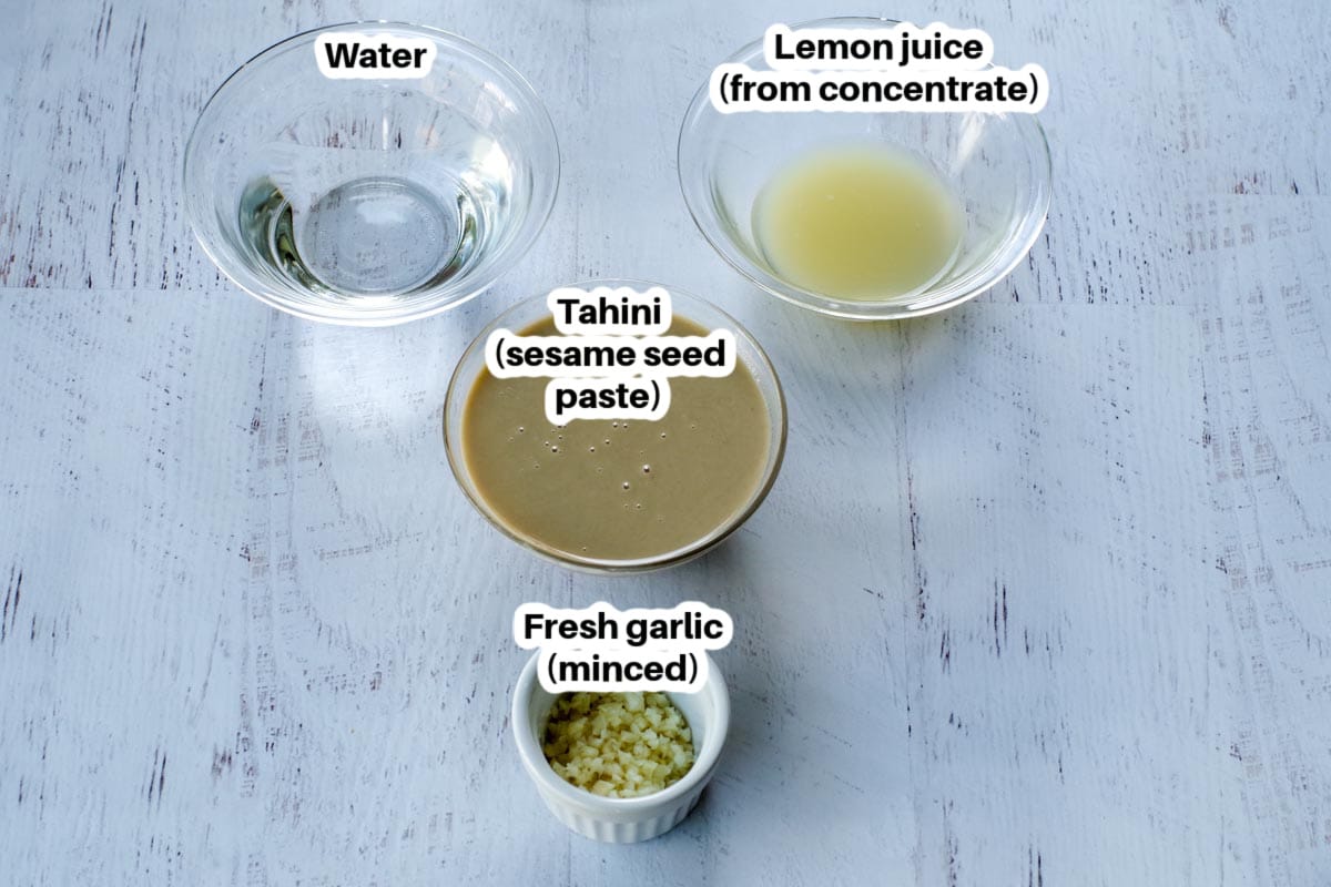 Tahini sauce ingredients in glass bowls, labelled