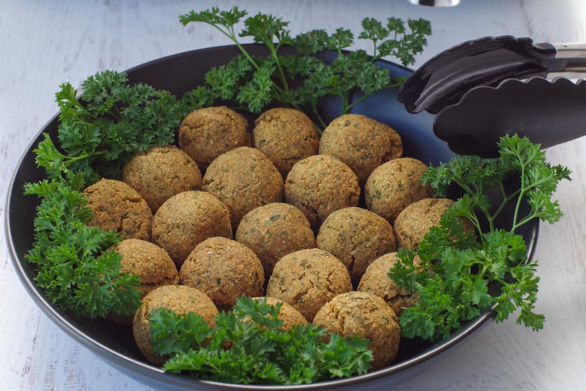 cooked air fryer falafel balls in a black bowl with parsley