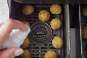 Falafel balls being sprayed with 2-3 pumps of oil