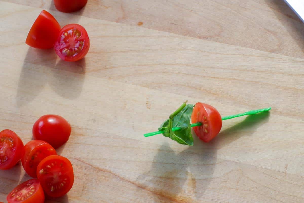 basil added to tomato on skewer