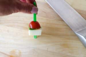 mozzarella added to skewer on wooden cutting board