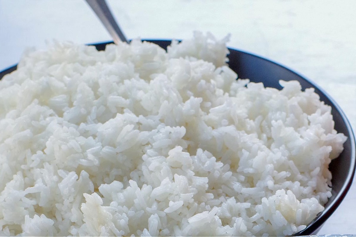 cooked Jasmine rice in a black bowl with a spoon