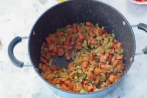 carrots and celery added to onions and garlic in soup pot