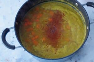 spices and pumpkin added to soup pot