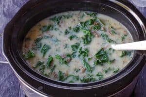 zuppa tosacana in slow cooker cooking on high for 10 minutes until thickened