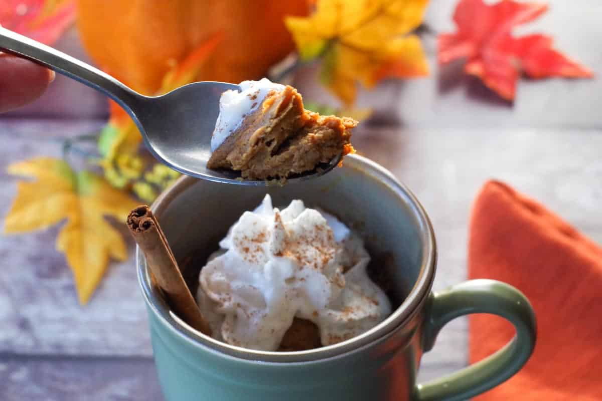 crustless pumpkin pie with whipped cream being held up on a spoon