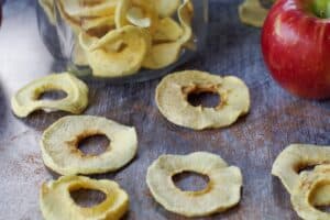 air fryer dehydrated apple rings in front of a jar of more dehydrated apples