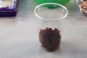 clear plastic cup with broken-up chocolate cake in the bottom of it
