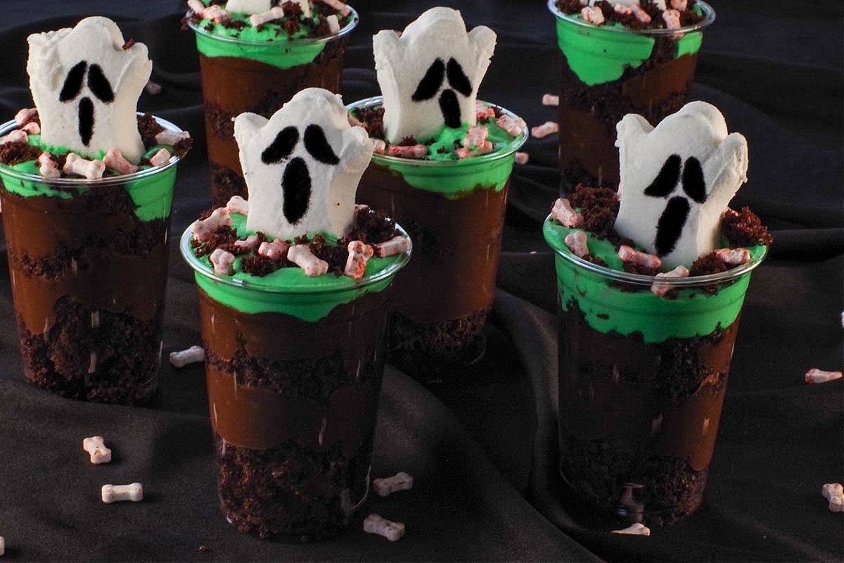 6 Boo! Halloween Dessert Cups on black surface with candy bloody bones strewn around