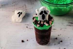 ghost peep placed in middle of cup with a little cake crumbs scattered and bloody bone candies placed in cup