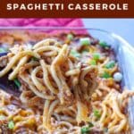 Million Dollar Spaghetti Casserole being lifted out of glass casserole dish on a wooden spoon