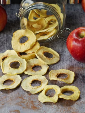 air fryer dehydrated apples spilled out of a jar of more dehydrated apples