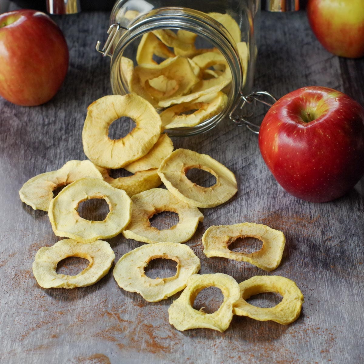air fryer dehydrated apples spilled out of a jar of more dehydrated apples