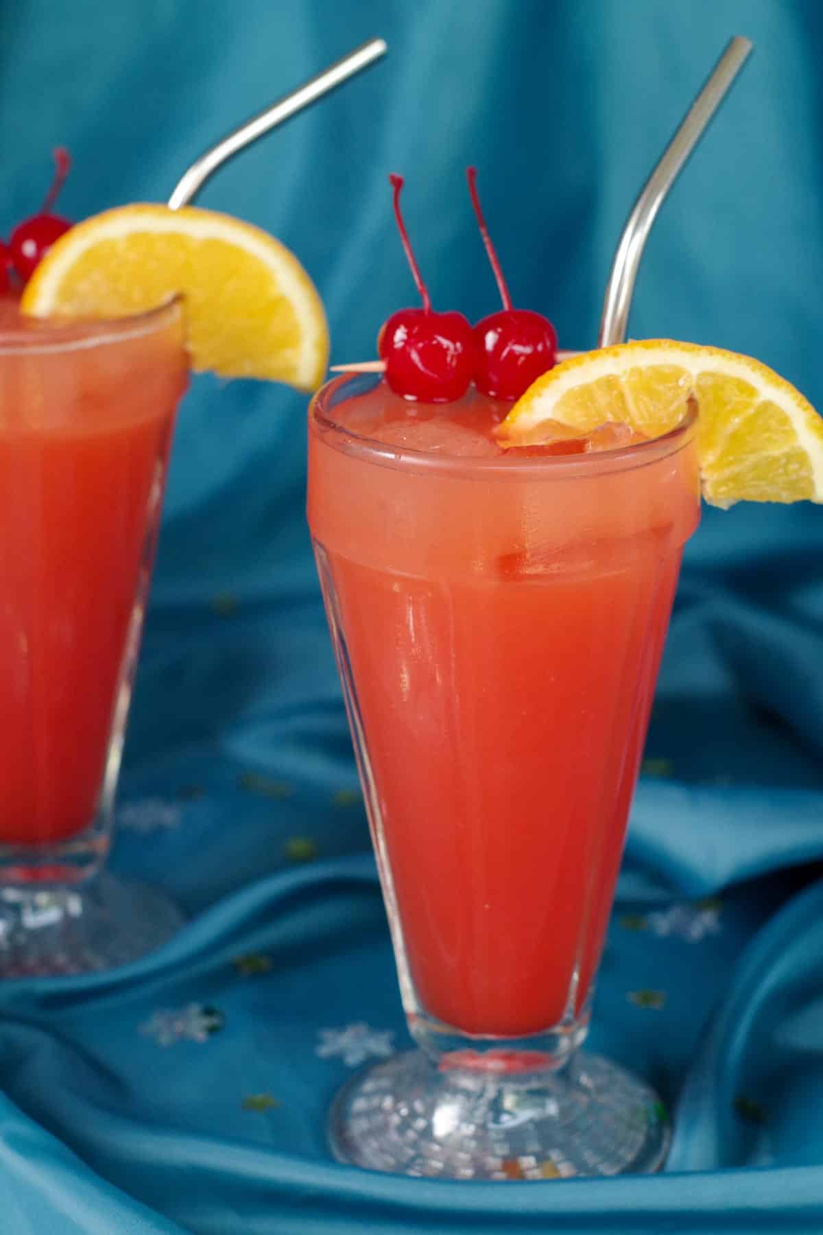 2 glasses of Shirley Temple drinks on blue material surface