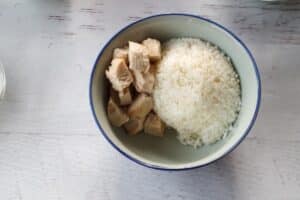sushi rice in a bowl with chopped, cooked chicken
