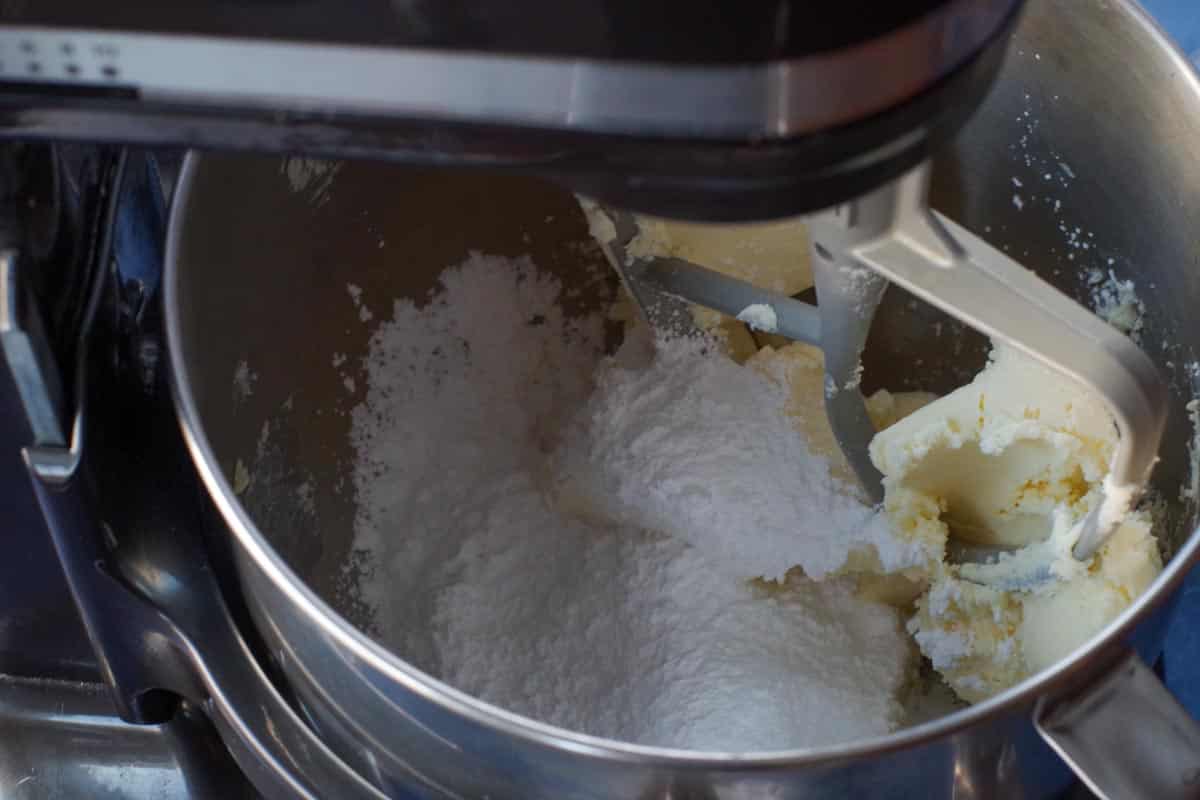 butter being creamed with icing sugar in stand mixer