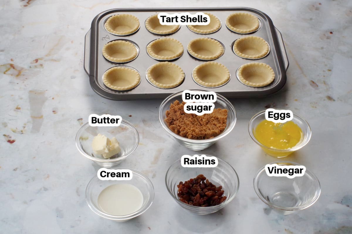 butter tart ingredients, in glass bowls, labelled (on granite counter surface)