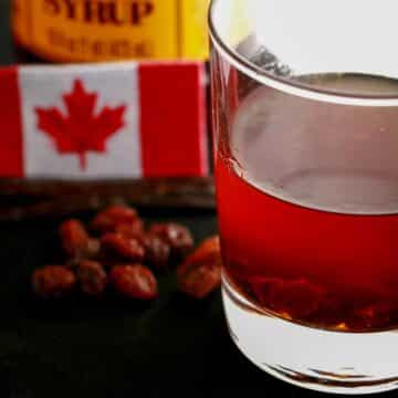 butter tart liqueur in a glass with a Canadian flag and raisins in the background