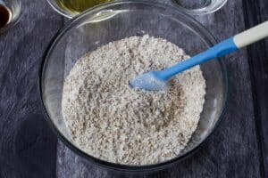 dry ingredients in a large glass bowl, with a blue spatula