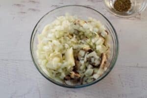 onions, mushrooms, butter and salt mixed together in a medium glass bowl