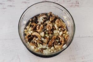 cooked mushrooms and onions, with salt and butter in a medium glass bowl