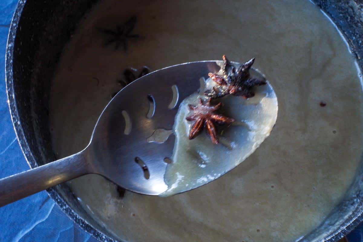 star anise being removed with slotted spoon