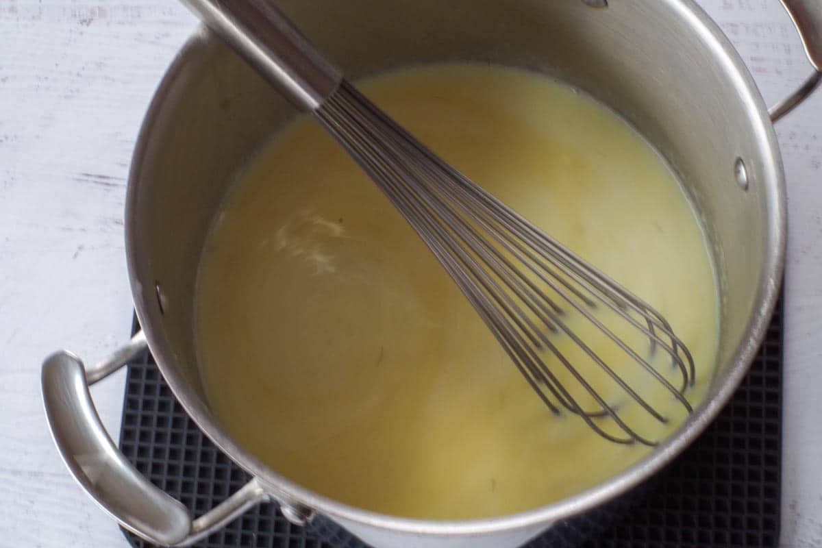 Whisk in pot with parmesan cheese added, mixing until combined