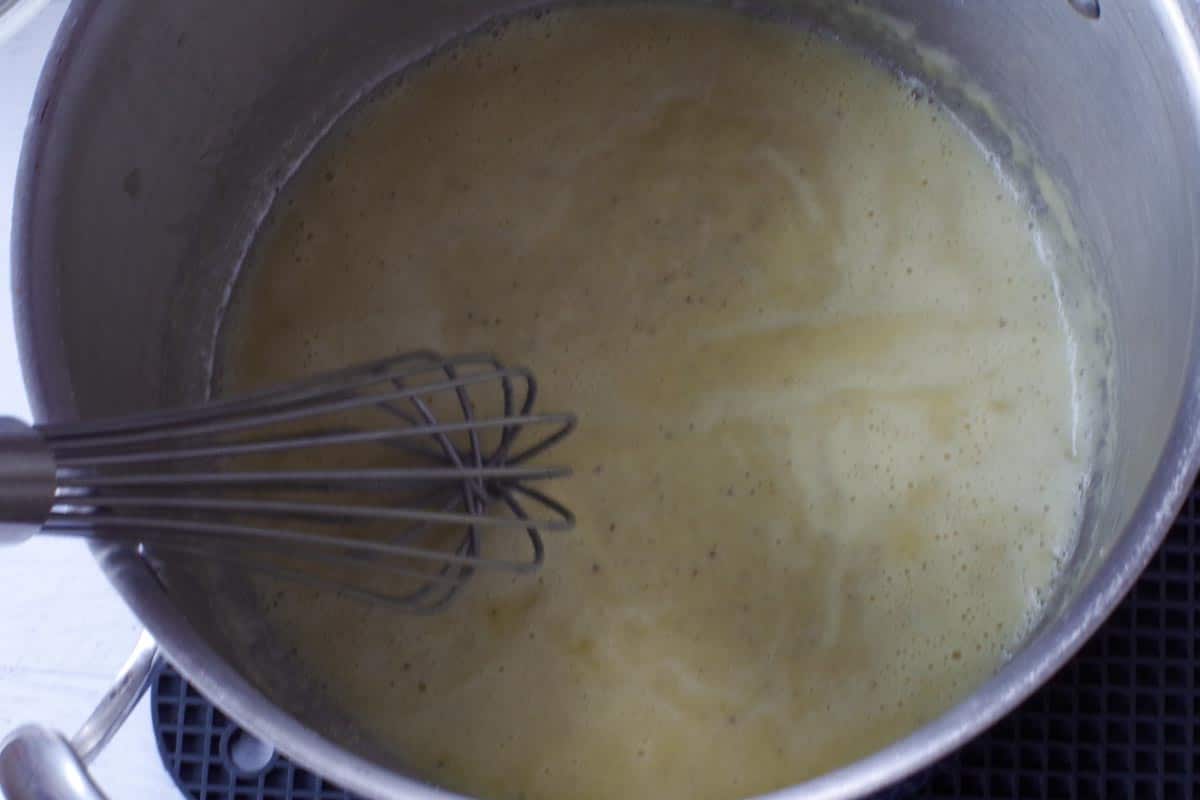 mixture being whisked until it becomes a smooth roux in large pot