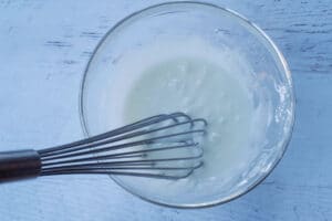 glaze ingredients whisked together in large glass bowl, with whisk in bowl
