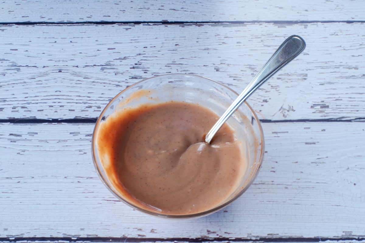 mayonnaise and Chipotle sauce mixed together in glass bowl, with spoon