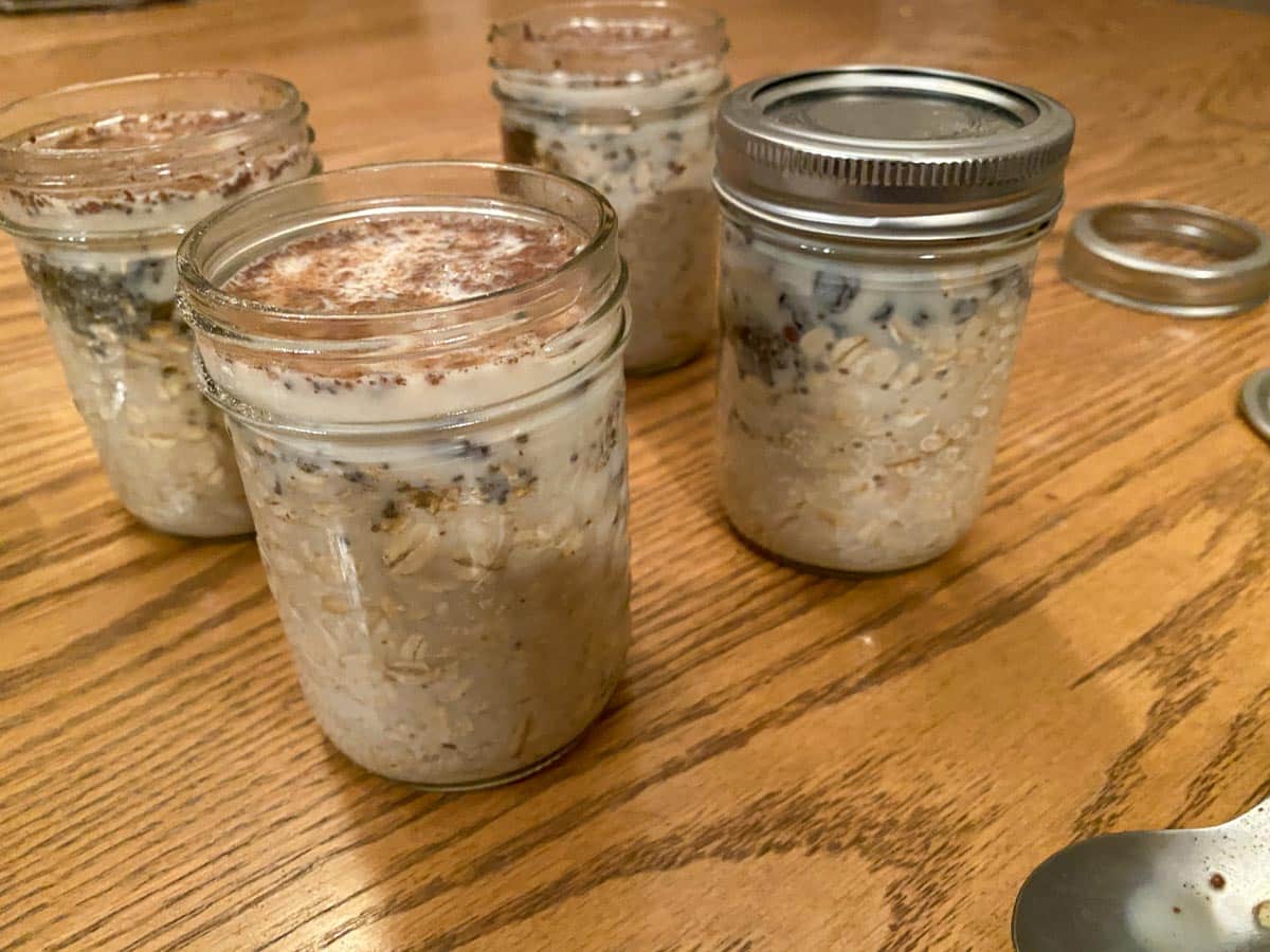 milk mixed in with oat mixture in glass jars