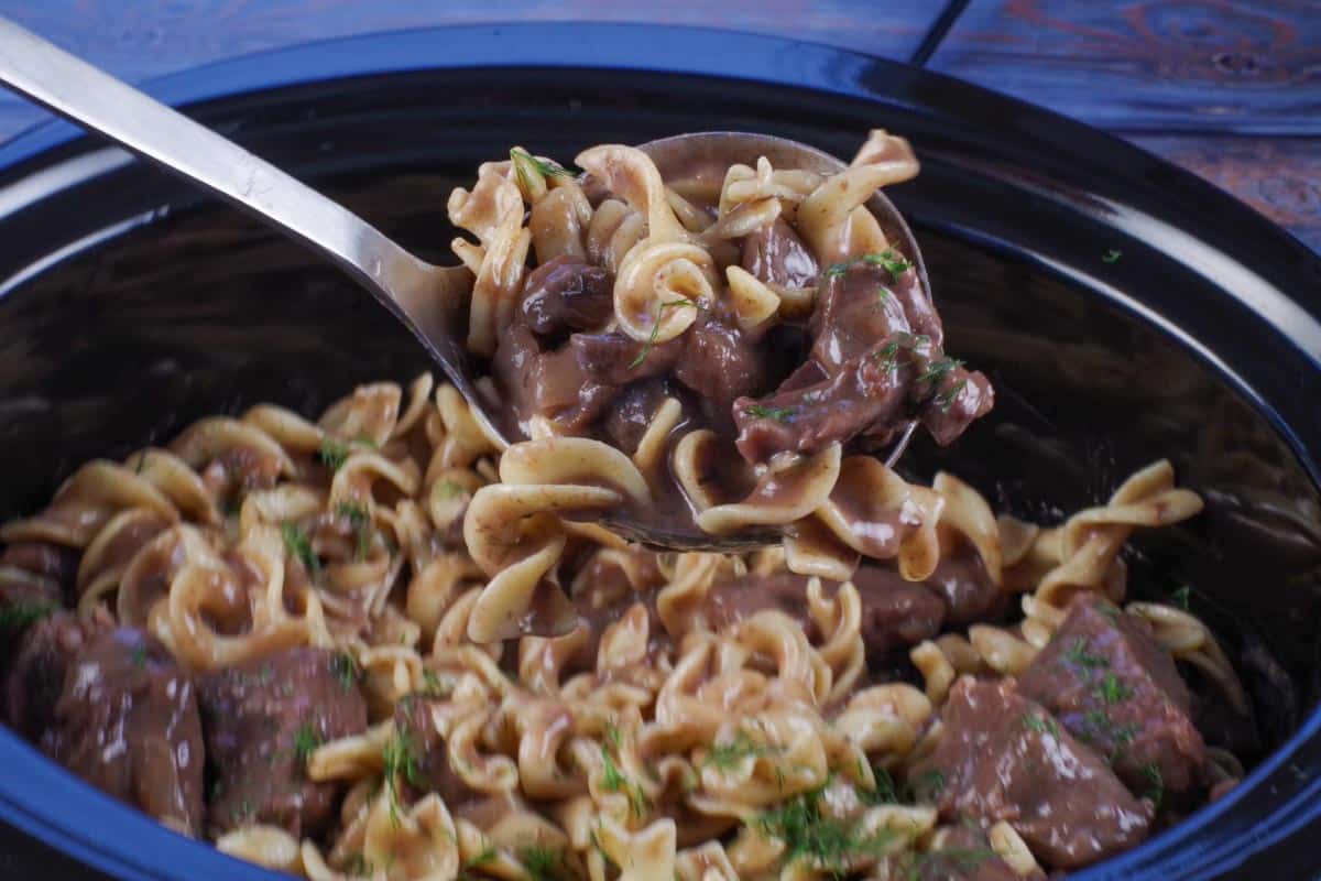 light beef stroganoff being scooped up on a ladle