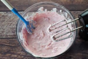 strawberries and Greek yogurt mixed in with cream cheese mixture, in a glass bowl