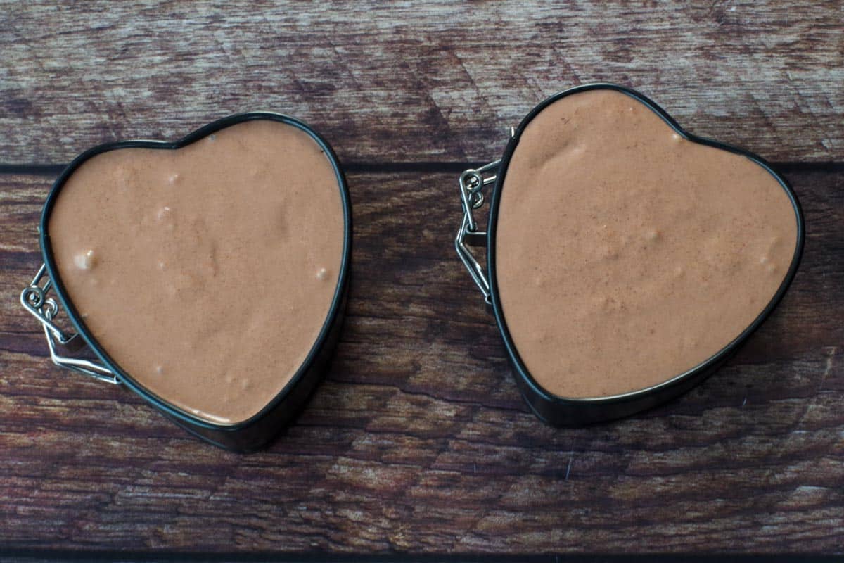 cheesecake batter poured into heart-shaped springform pans
