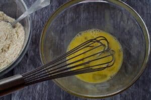 eggs in a glass bowl with a metal whisk