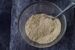 bread crumb mixture in a glass bowl with a metal whisk