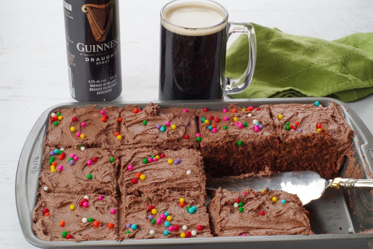 a pan with chocolate guinness cake with a glass of beer and can of beer in background
