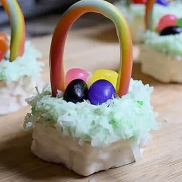 Mini Easter basket cake on wooden surface with more mini Easter basket cakes in the background