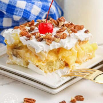 slice of No Bake Twinkie Cake on white plate with blue and white checked linen in the background