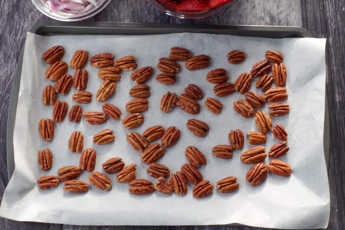 pecans on a parchment lined baking sheet