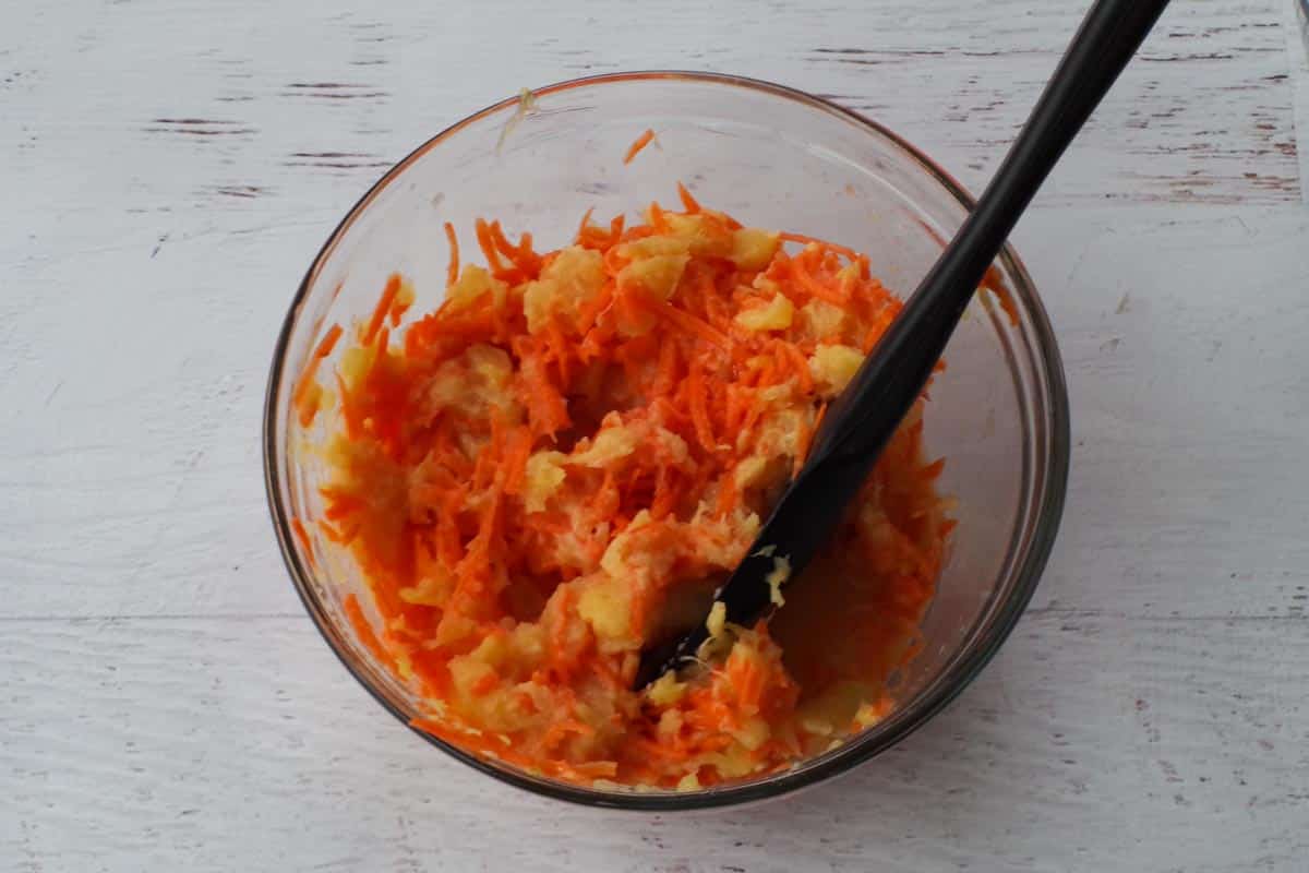 carrots, pineapple, apple sauce mixed together in a medium glass bowl