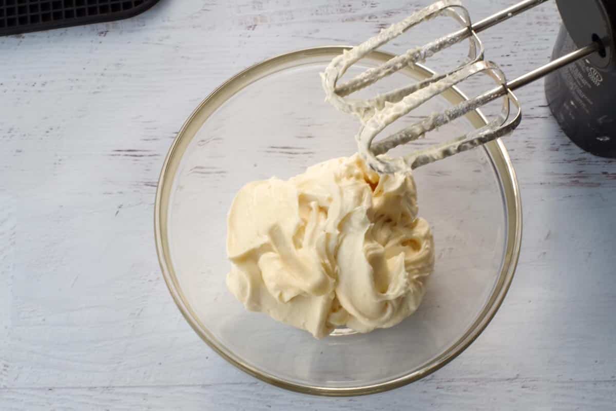 sweet cream cheese butter in a glass bowl with beaters over bowl