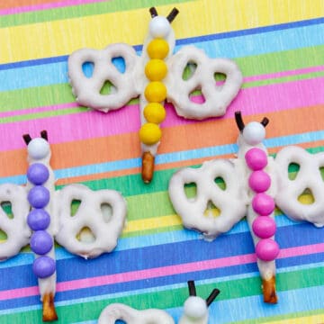 4 rainbow dragonfly pretzels on a multicolored background