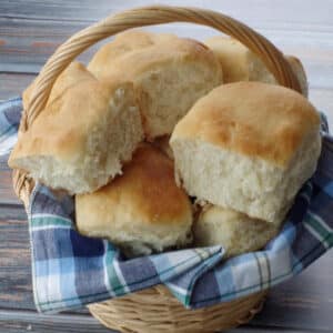 several granny buns in a basket with a blue checked cloth