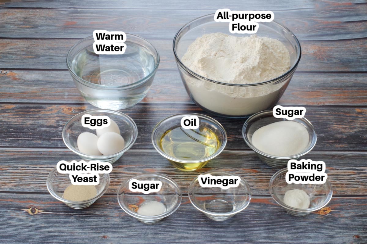 ingredients in Granny Buns in glass bowls, labelled, on a faux wood surface