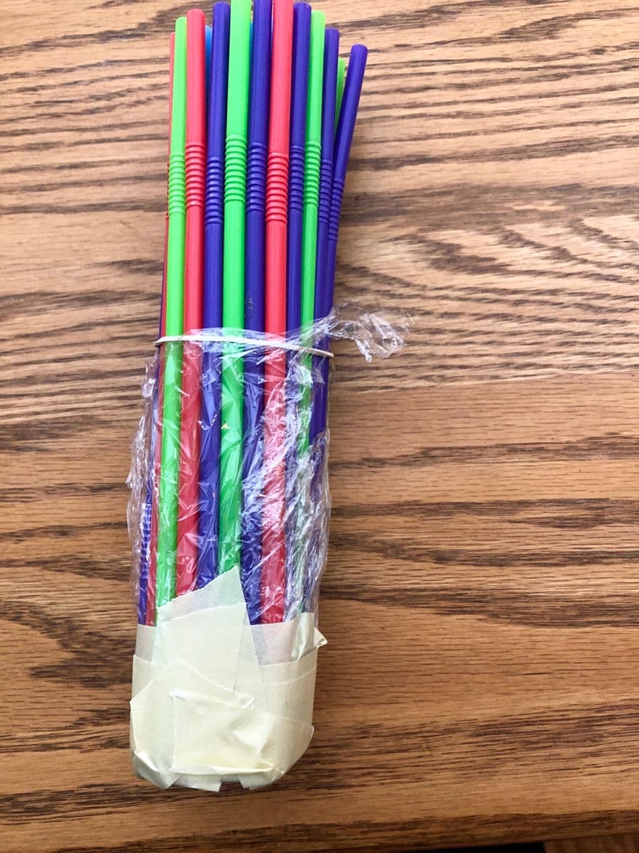 straws held together with elastic, with saran wrap and tape on the bottom