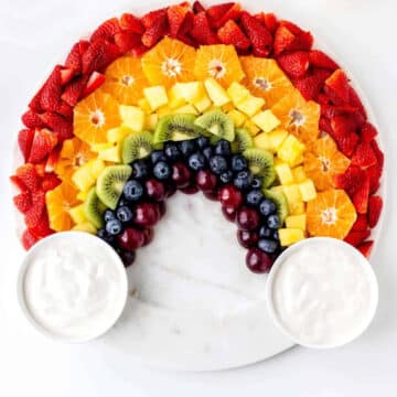 rainbow of fresh fruit with round bowls of dip on either side